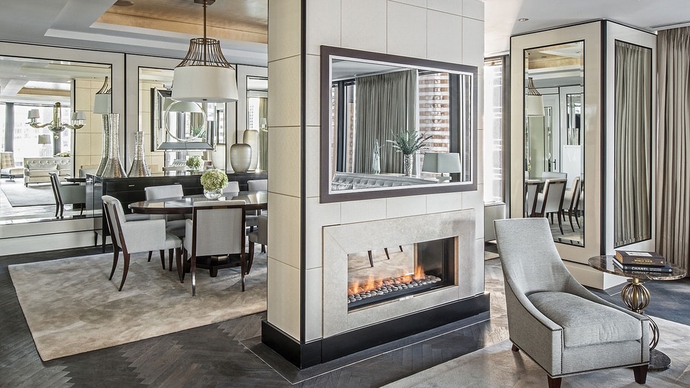 Regent Suite Dining Room at the Langham Hotel with a fire place and dinning table and mirrored covered walls