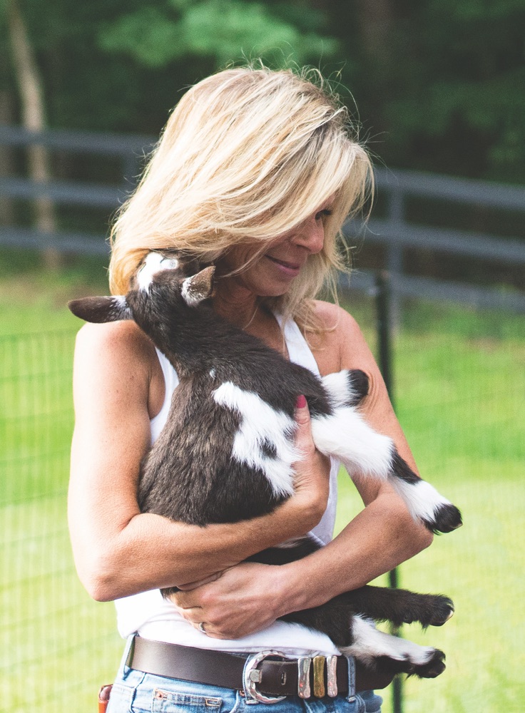 Owner Cathi Huff holding a baby goat at Atlantis Dream Farm