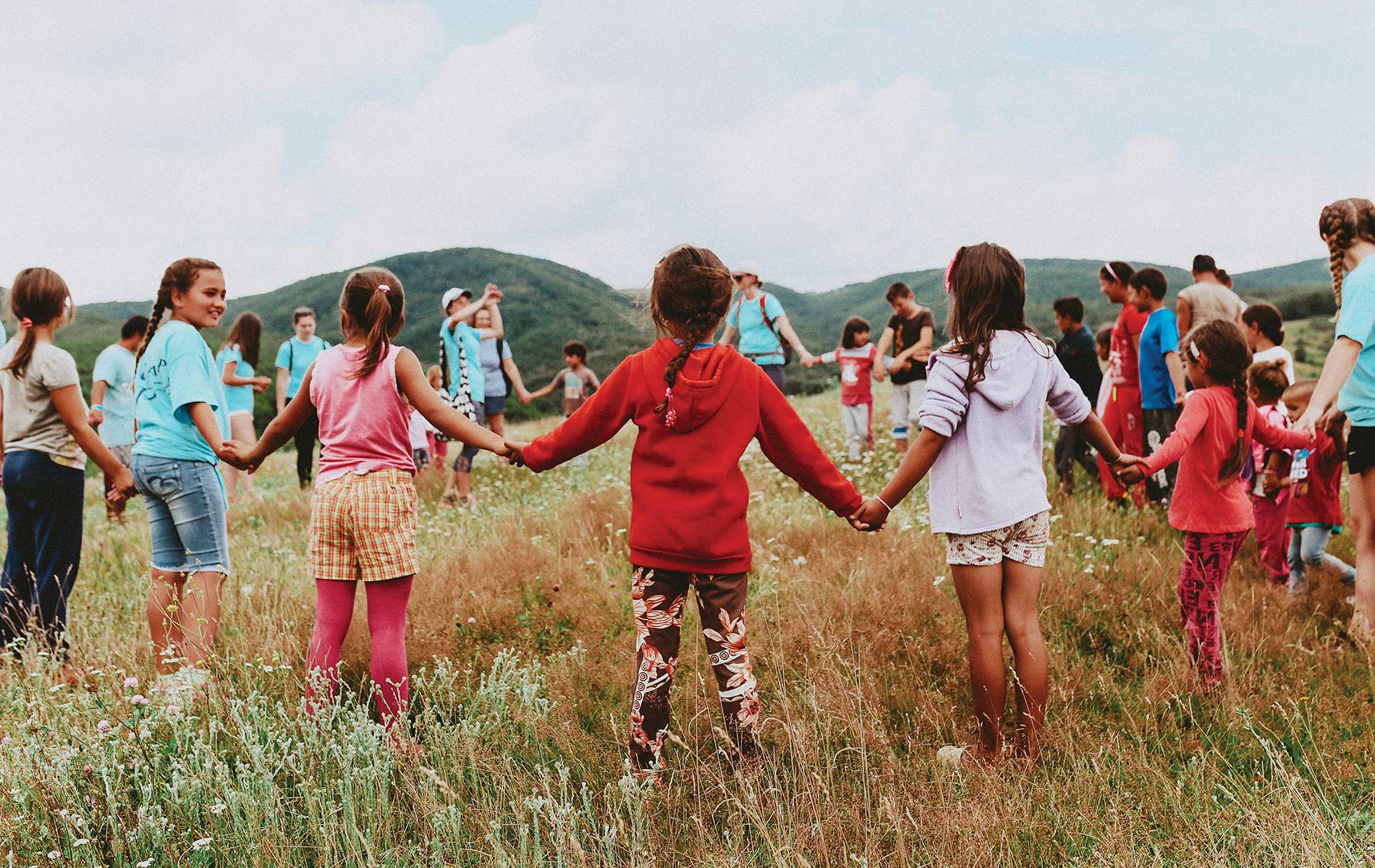 Children in a field holding hands