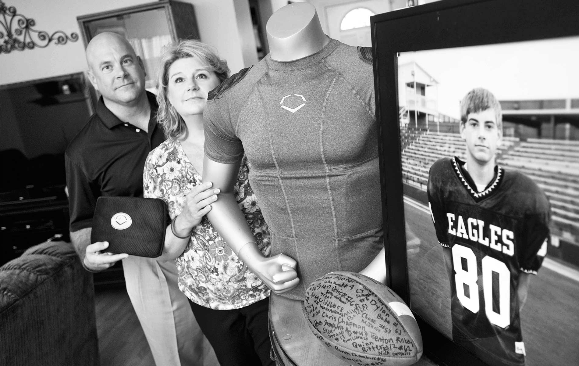 Brian and Kathy Haugen display the rib-protecting shirt that could have saved their son’s life. Now they dedicate funds from the Taylor Haugen Foundation to equipping young athletes with this and other protective gear. | Photo courtesy of Taylor Haugen Foundation