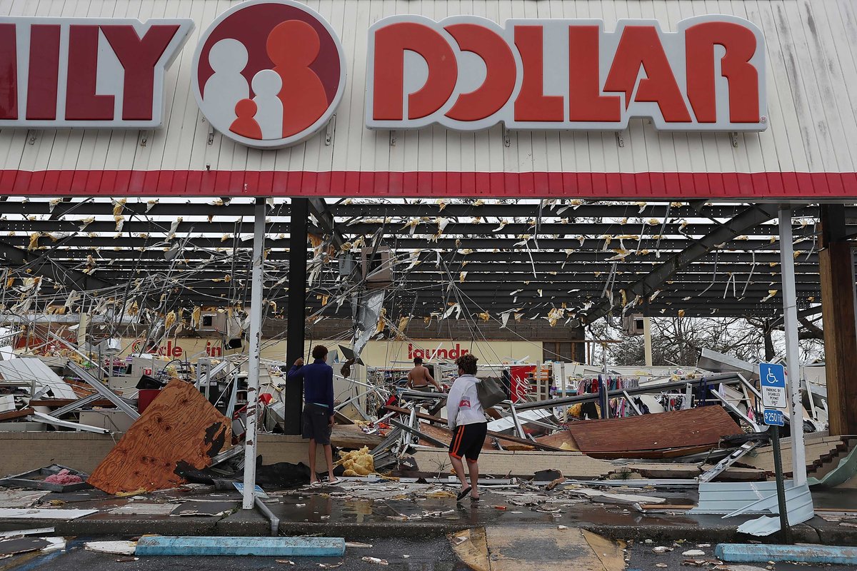 People look on at a damaged store after Hurricane Michael passed through on Oct. 10, 2018 in Panama City, FL.