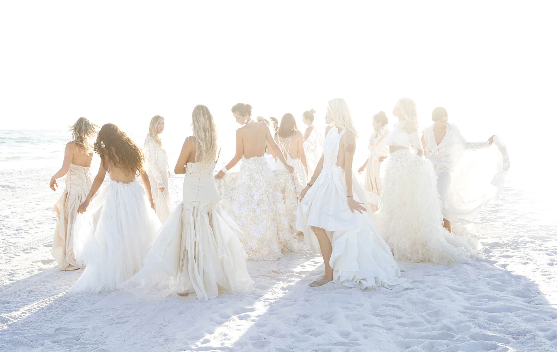 Nicole Paloma Bridal, group shot of models in wedding gowns on the beach