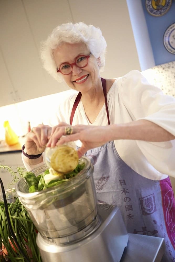 Paula Lambert prepping some pesto to serve at her dinner party at her Turtle Creek home in Dallas, Texas