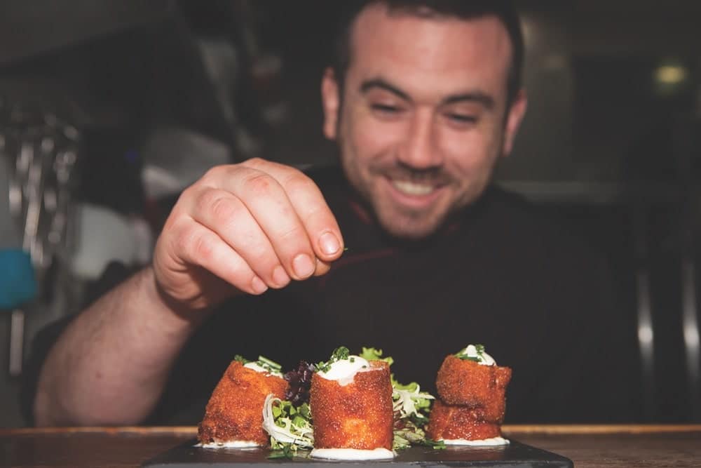 Chef Fernando of Toma and Coe food tours puts the final touch on some Spanish tapas.