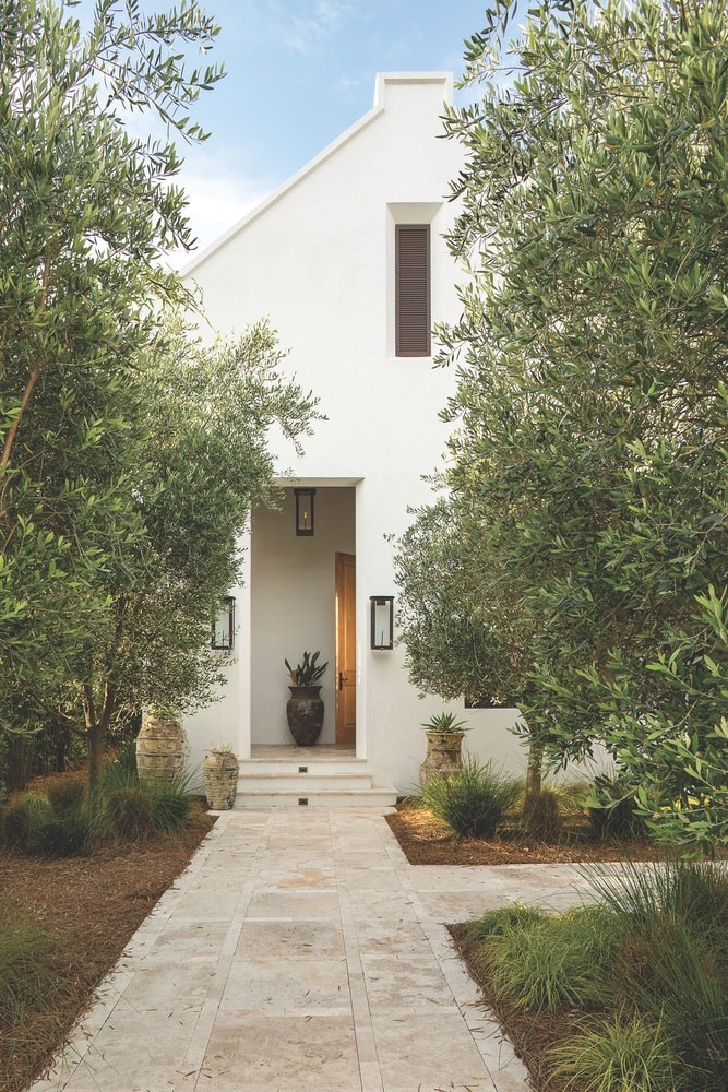 Olive trees line the entry sequence into the Cape Dutch–influenced Finley residence in Inlet Beach, Florida, A Boheme Design, A Boheme