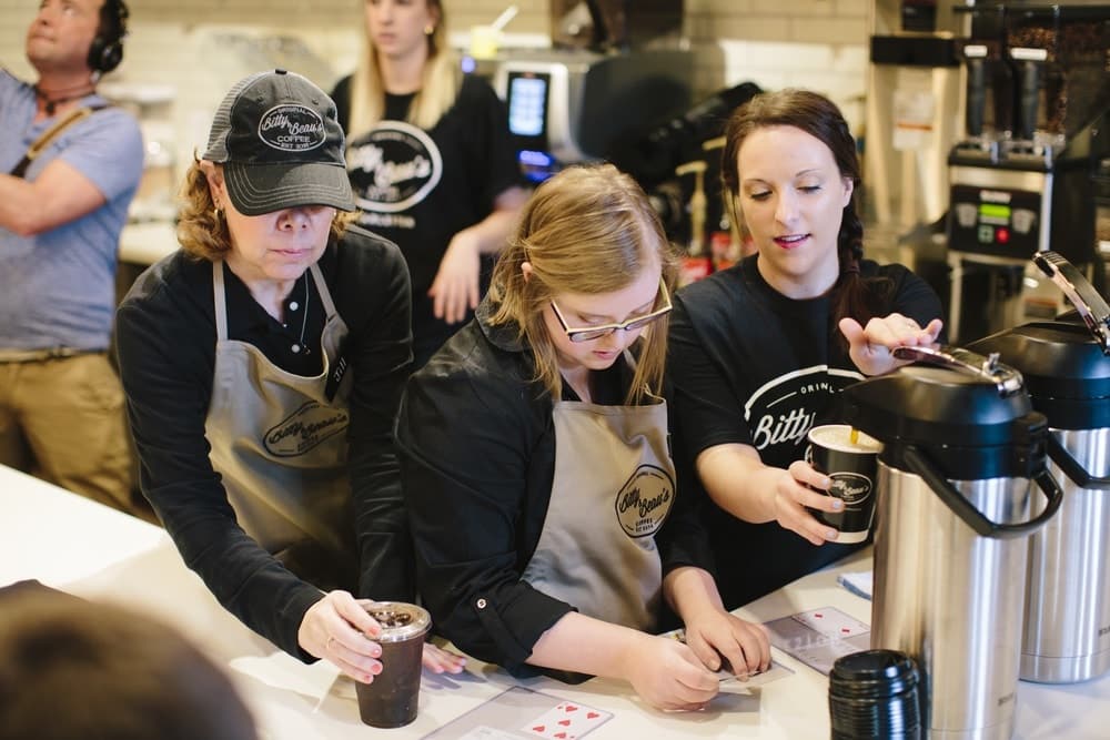 Three employees preparing coffee orders at Bitty & Beau's Charleston location.