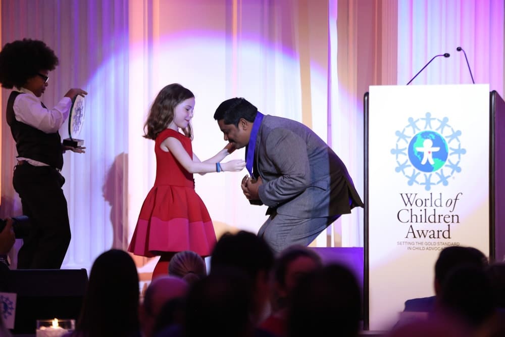 Honoree Iyyappan Subramaniyan accepts an award on stage during the World of Children Awards Ceremony
